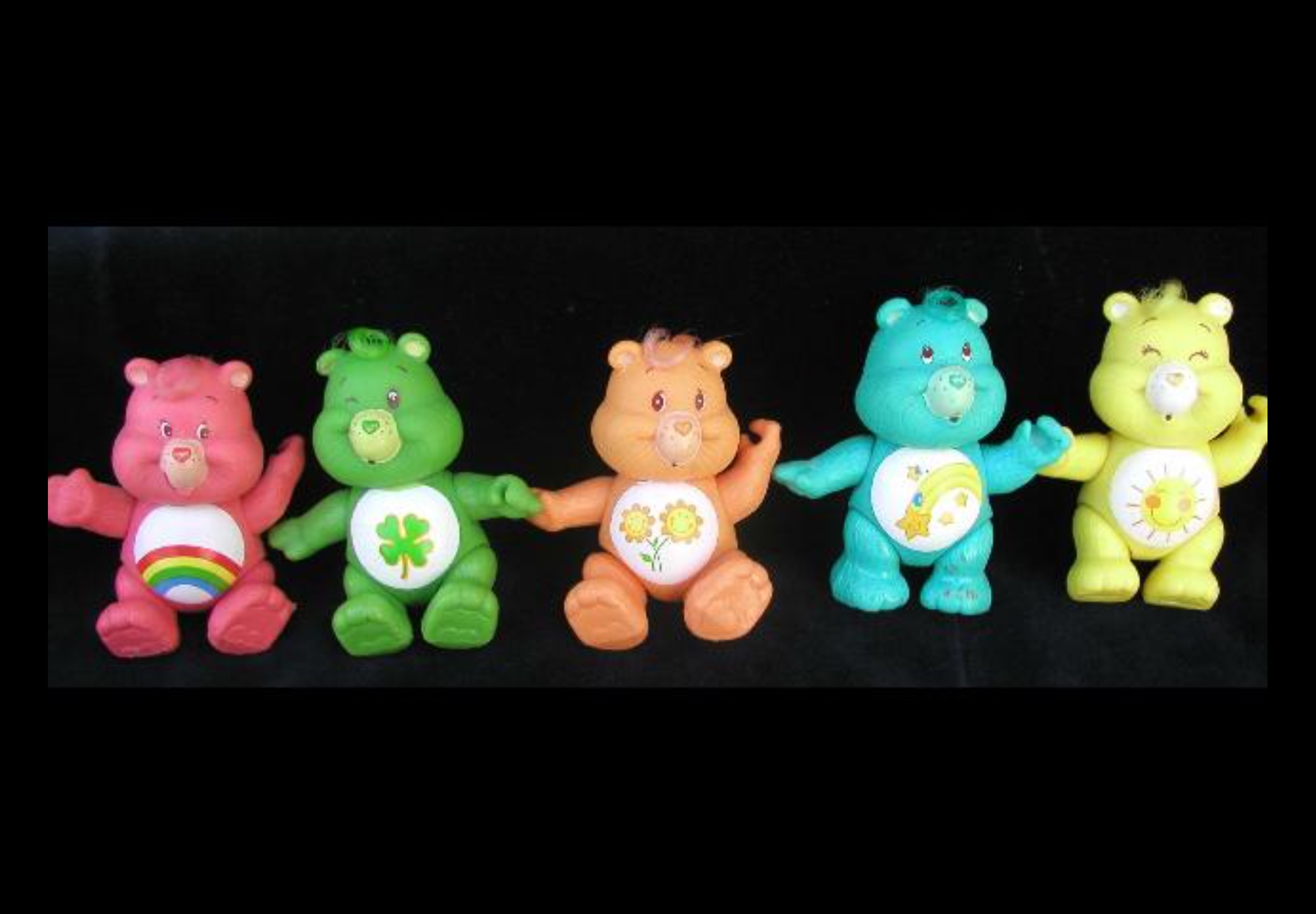 Five colorful vintage Care Bears poseable figures arranged in a row