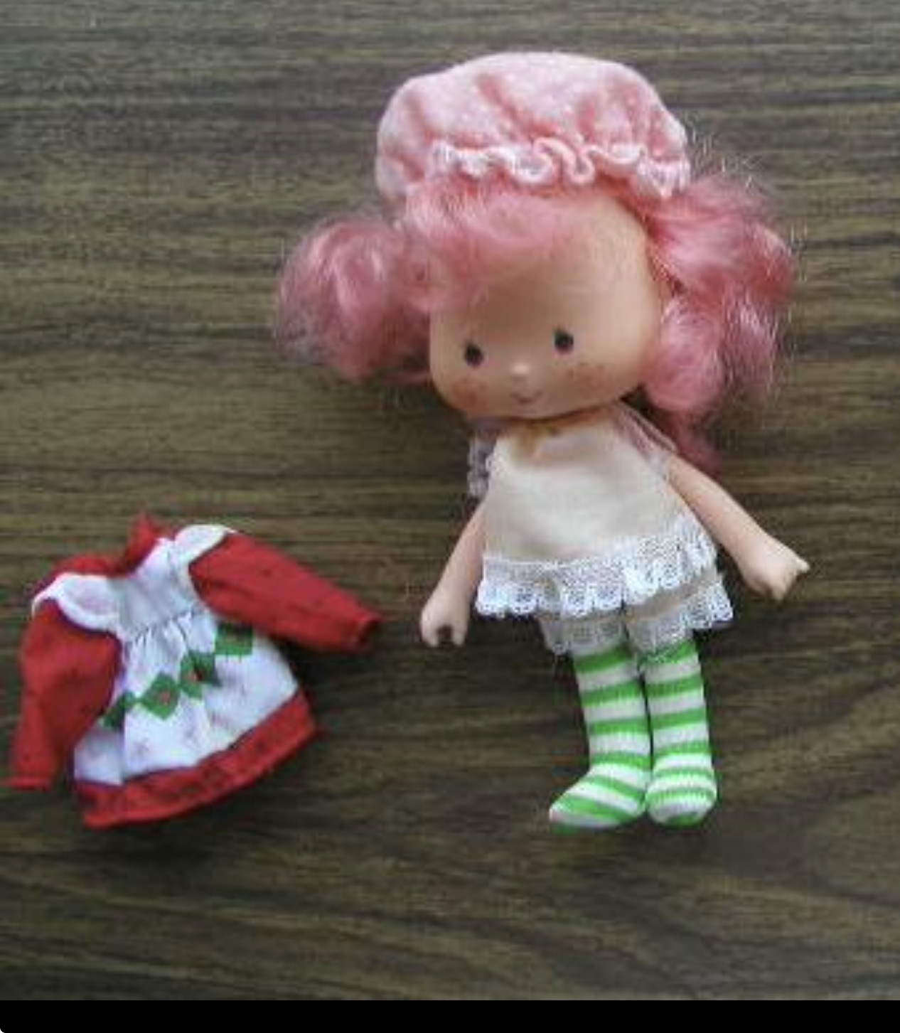 Vintage pink-haired Strawberry Shortcake doll in bonnet with an extra red dress